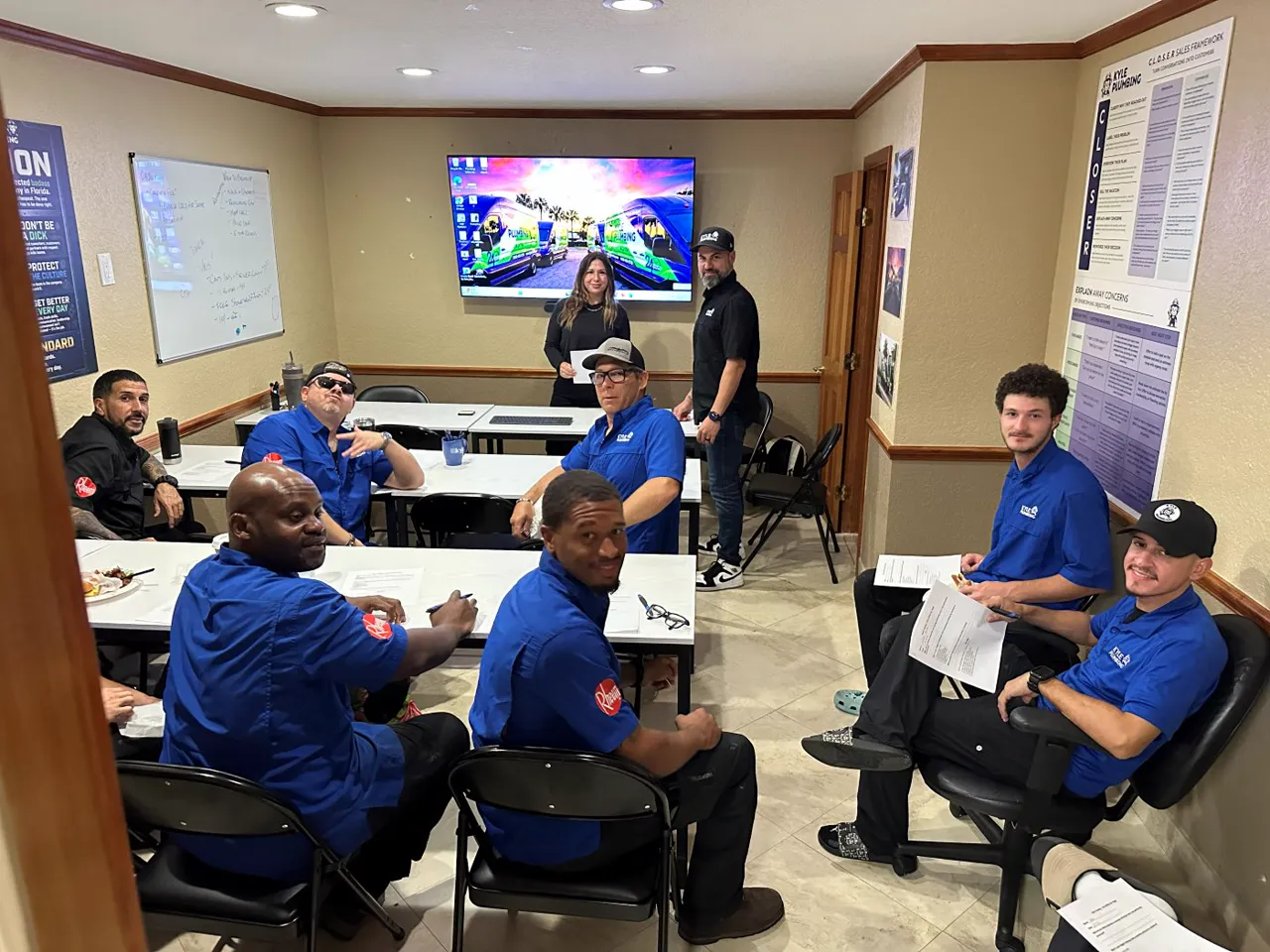 Technicians in blue uniforms at tables during a training session