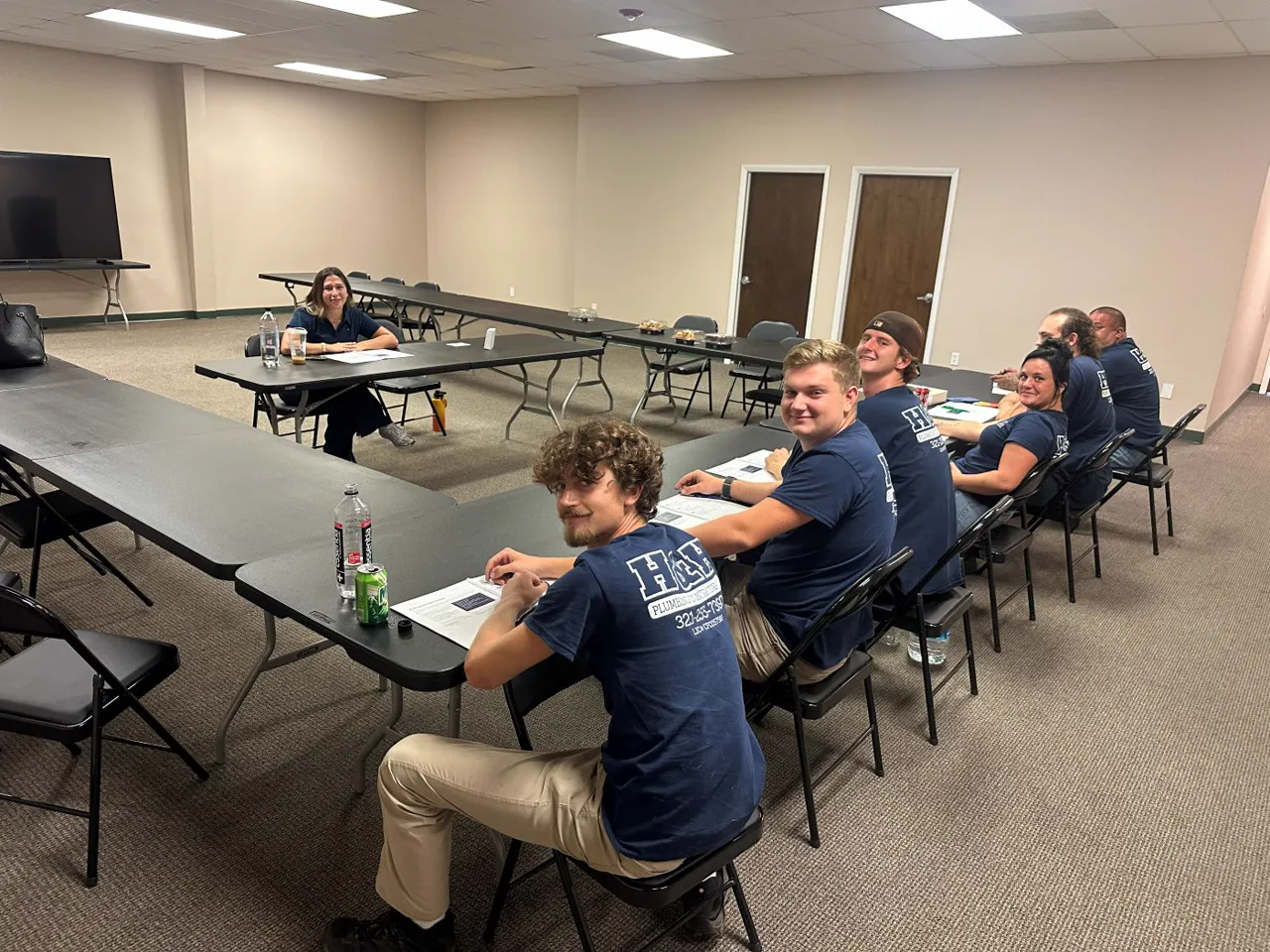 Technicians seated at tables in a training room