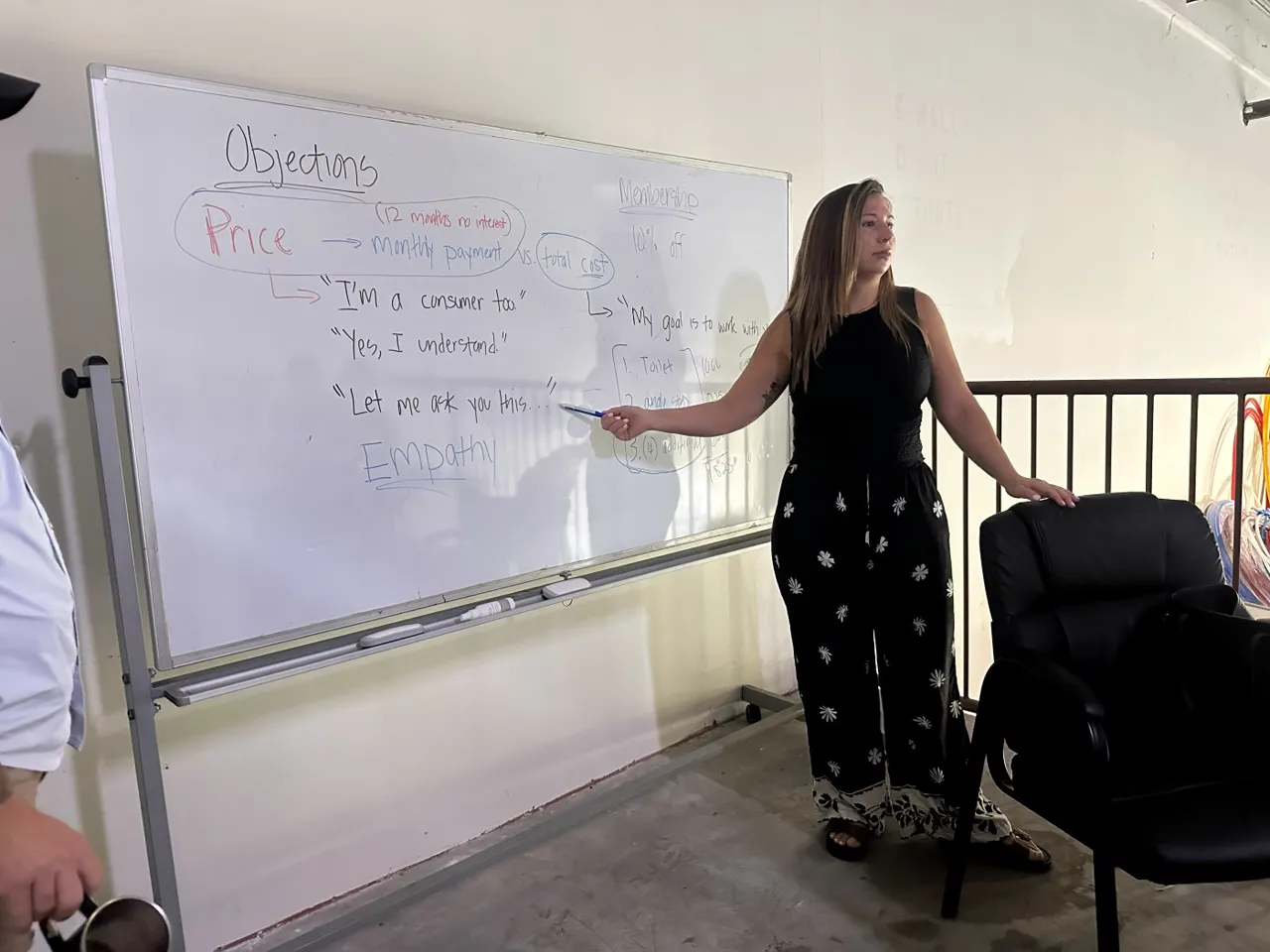 A Stratella trainer working through customer objections on a whiteboard